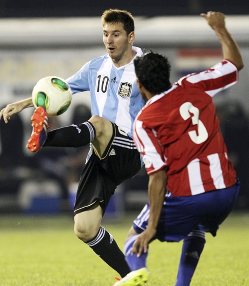 Argentina's Lionel Messi (left) controls the ball next to Paraguay's Salustiano Candia