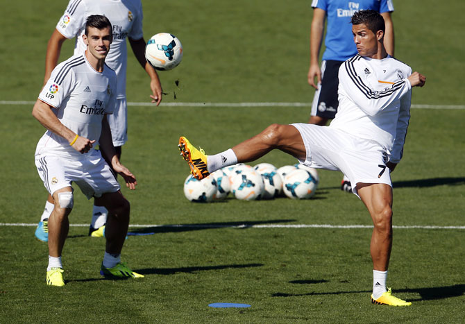 Real Madrid's Gareth Bale (L) and Cristiano Ronaldo challenge for the ball during their training session at Valdebebas sports grounds in Madrid