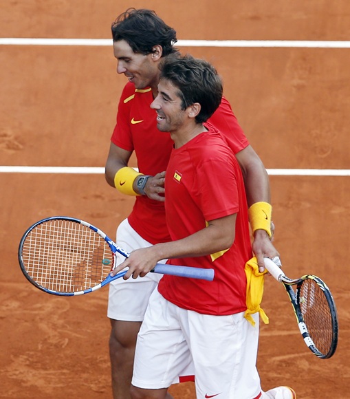 Spain's Rafael Nadal (top) celebrates with teammate Marc Lopez