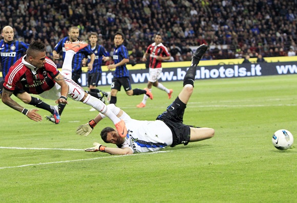 Inter Milan's goalkeeper Julio Cesar (bottom) dives to make a save from AC Milan's Kevin Prince Boateng 