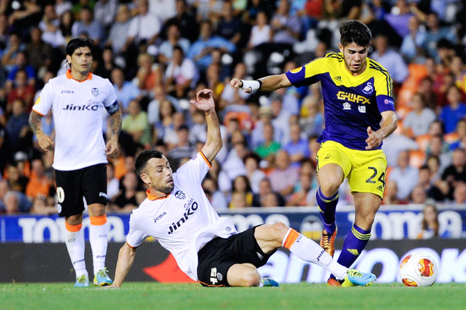 Alejandro Pozuelo of Swansea City duels for the ball with Javi Fuego of Valencia CF during the UEFA Europa League