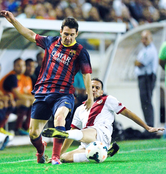 Lionel Messi of FC Barcelona duels for the ball with Nacho Martinez of Rayo Vallecano