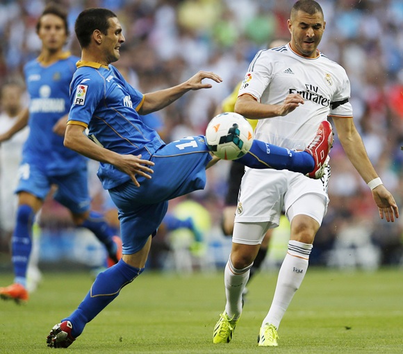 Real Madrid's Karim Benzema (right) and Getafe's Alvaro Arroyo fight for the ball