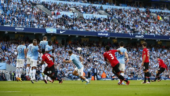 Manchester United's Wayne Rooney (R) shoots to score against Manchester City