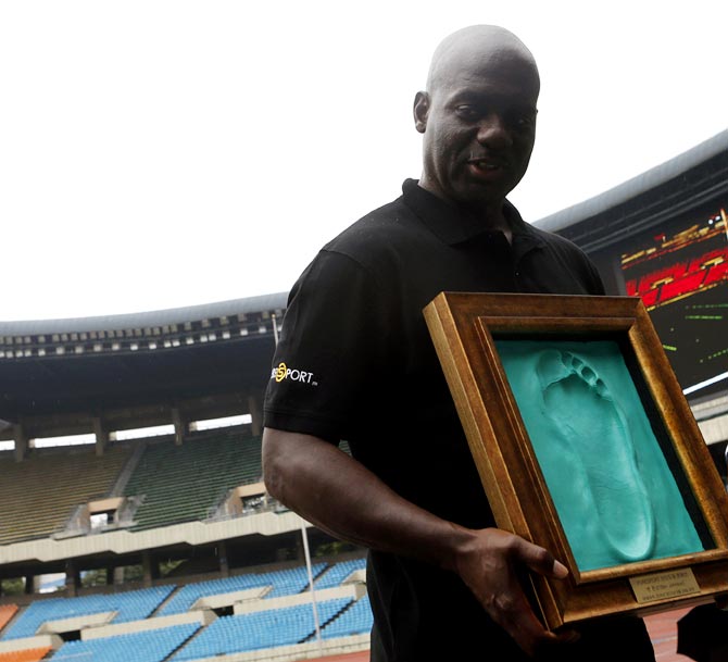 Ben Johnson holds a cast of his footprint made after running on the track at the Seoul Olympic Stadium