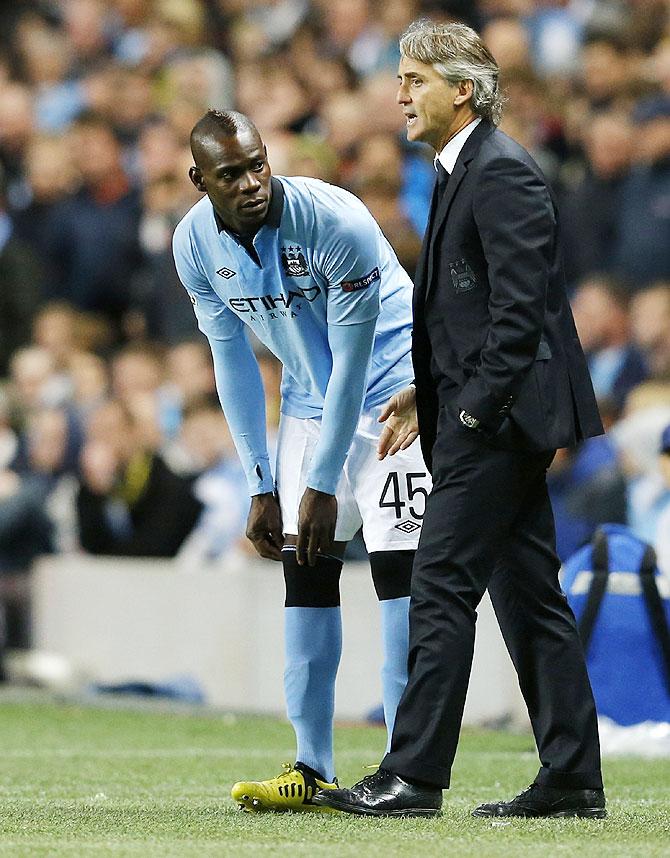 Mario Balotelli (left) with coach Roberto Mancini during his days with Manchester City