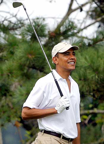 US President Barack Obama watches his tee shot while golfing at Mink Meadows golf course