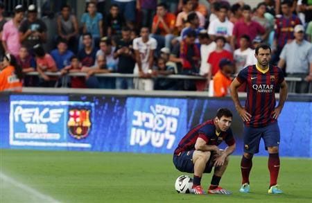 Barcelona's Lionel Messi (left) sits on a ball next to teammate Javier Mascherano