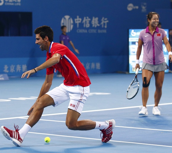 Serbia's Novak Djokovic (left) tries to catch the ball as China's Li Na looks on