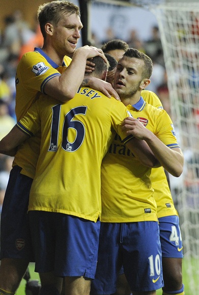 Arsenal's captain Per Mertesacker (left) celebrates the goal of Aaron Ramsey (centre) with Jack Wilshere