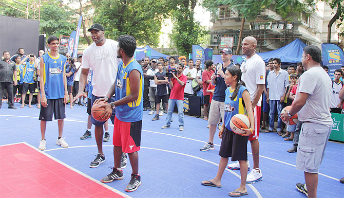 Horace Grant teaches a kid how to score a basket during NBA Jam Mumbai edition on Sunday