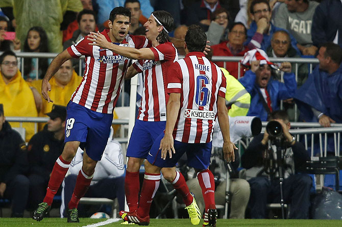 Atletico Madrid's Diego Costa (left) celebrates a goal with teammates Filipe and Koke (right) during the Spanish La Liga match against Real Madrid at Santiago Bernabeu stadium in Madrid on Saturday