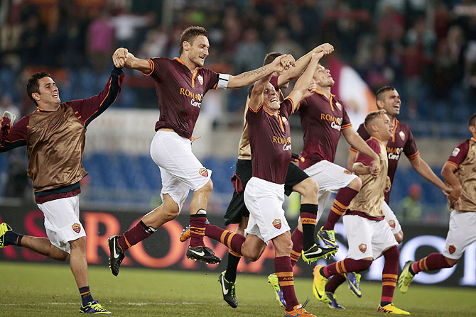 Roma players celebrate at the end of their Italian Serie A soccer match against Bologna at the Olympic stadium in Rome on Sunday