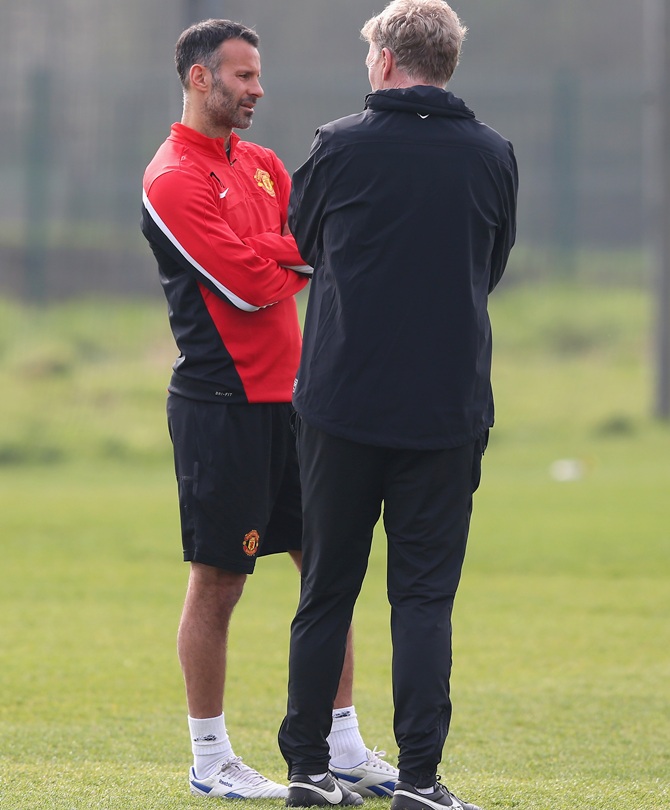 David Moyes the manager of Manchester United talks with Ryan Giggs