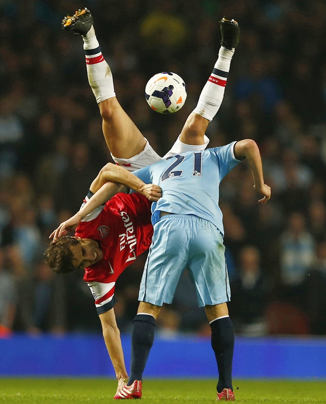 Arsenal's Mathieu Flamini, left, challenges Manchester City's David Silva