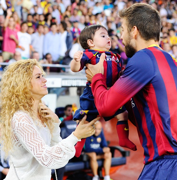 Shakira and Gerard Pique of FC Barcelona with their son Milan at a football match