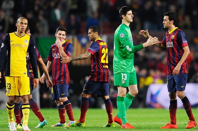 Goalkeeper Thibaut Courtois of Club Atletico de Madrid shakes hands   with Sergio Busquets of Barcelona as Lionel Messi of Barcelona grimaces