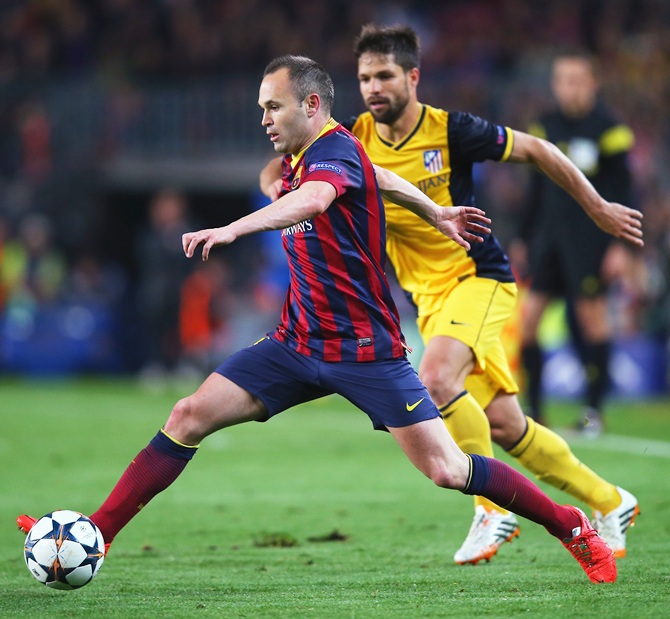 Andres Iniesta of Barcelona goes past Diego of Club Atletico de Madrid