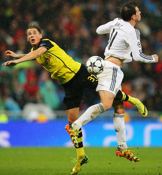 Erik Durm of Borussia Dortmund jumps with Gareth Bale of Real Madrid 