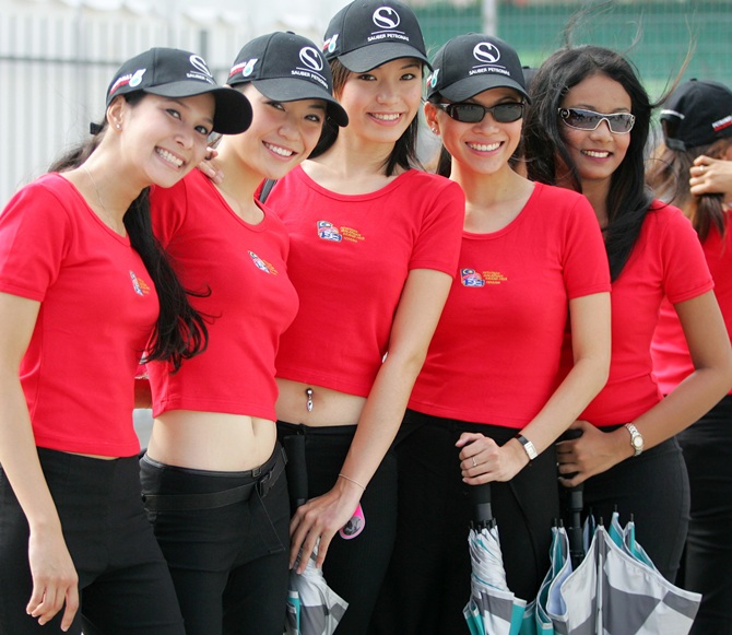 Grid girls pose for a photo after arriving on Sepang circuit for rehearsal on the eve of the Malaysian Grand Prix in Sepang, outside Kuala Lumpur, March 19, 2005