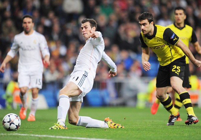 Gareth Bale of Real Madrid scores the opening goal watched by Sokratis Papastathopoulos of Borussia Dortmund