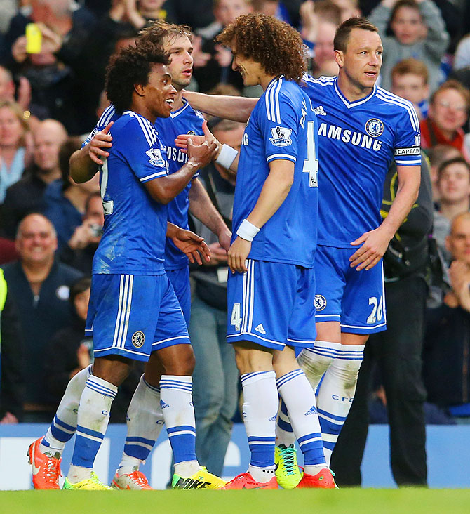 Chelsea players celebrate a goal by Willian