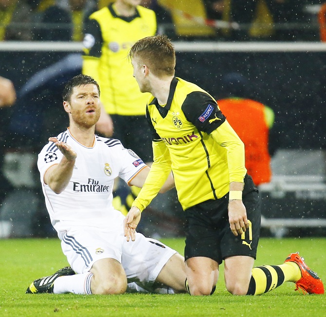 Real Madrid's Xabi Alonso,left, reacts in front of Borussia Dortmund's Marco Reus