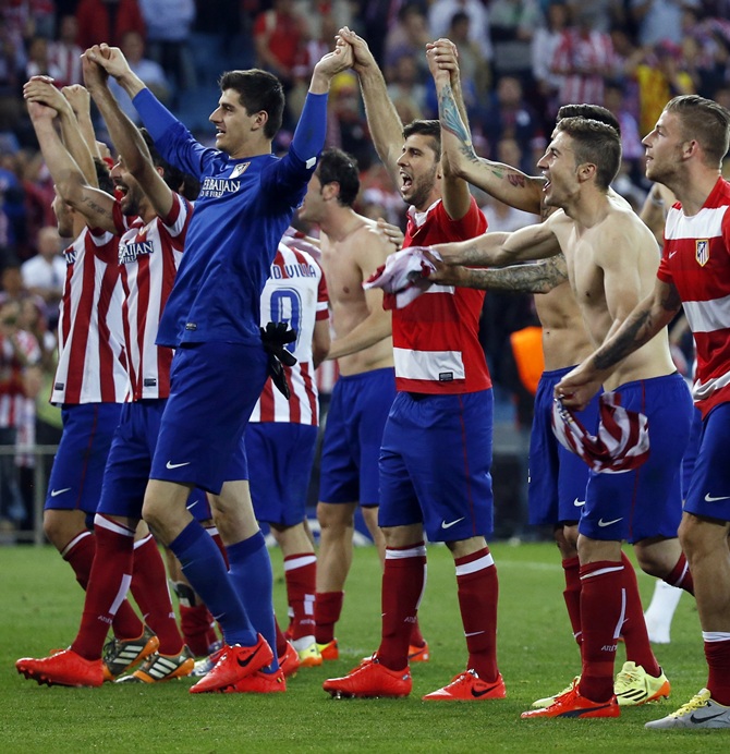 Atletico Madrid players react after winning their Champions League quarter-final second leg soccer match against Barcelona, in Madrid
