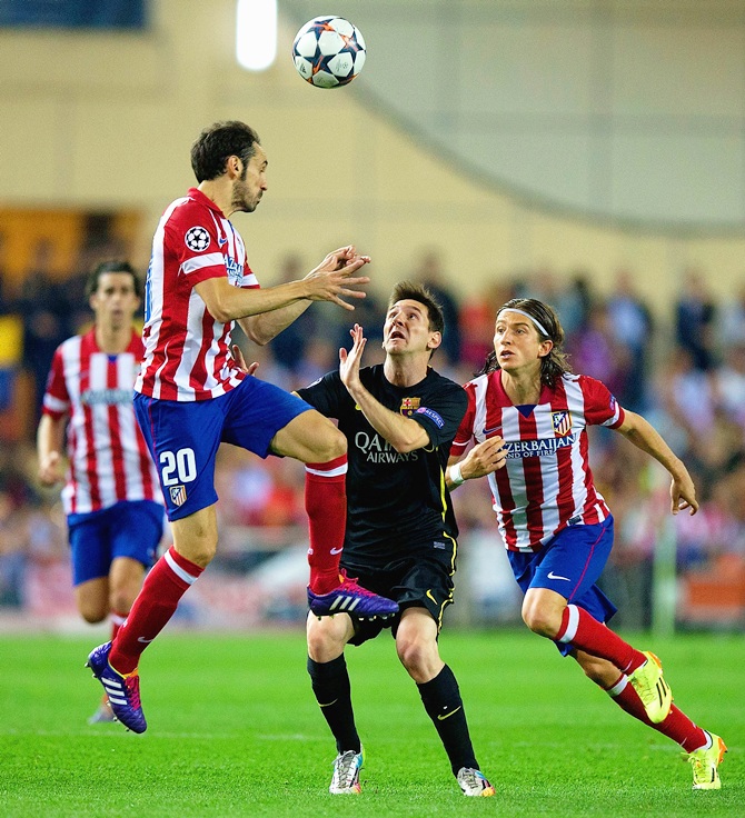 Juanfran of Club Atletico de Madrid climbs above Lionel Messi of Barcelona