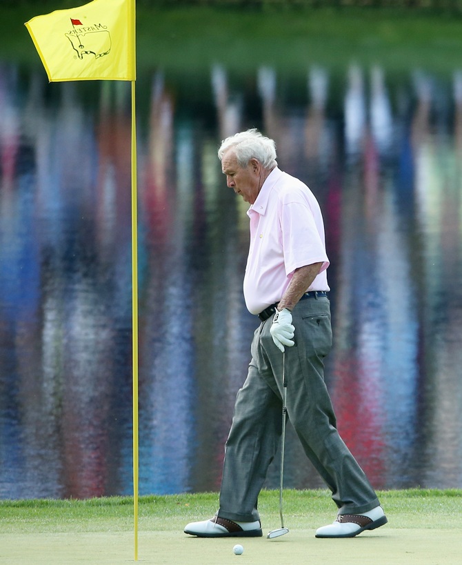 Arnold Palmer walks off a green during the 2014 Par 3 Contest prior to the start of the 2014 Masters Tournament