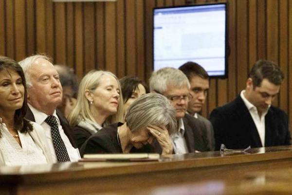 A member of the entourage of Oscar Pistorius holds her head while he testifies during his trial at the North Gauteng high court in Pretoria, on April 10