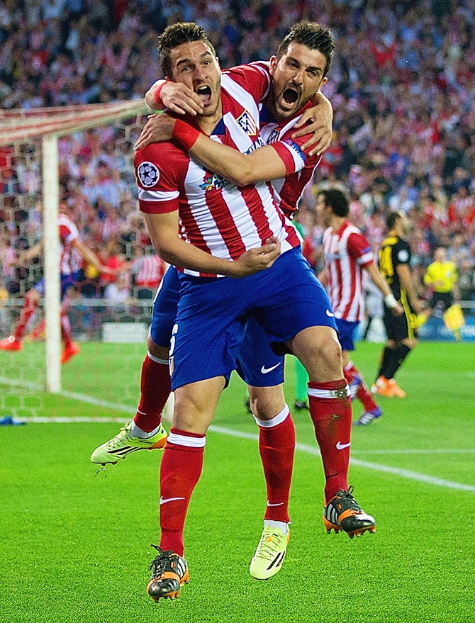 Koke celebrates with Atletico de Madrid teammate David Villa after scoring against Barcelona on Wednesday night in the Champions League
