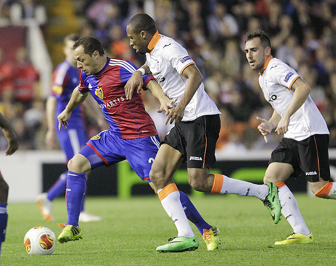 FC Basel's Marcelo Diaz (left) and Valencia's Seydou Keita (centre) vie for possession as Valencia's Paco Alcacer watches on Thursday