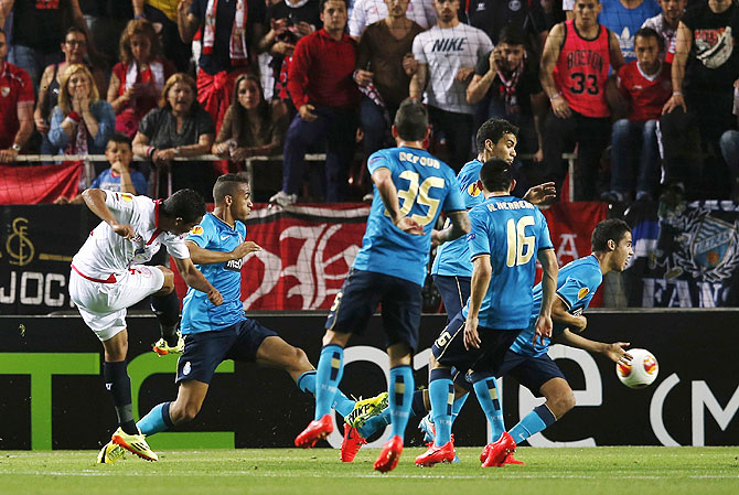 Sevilla's Carlos Bacca (left) kicks the ball to score against Porto on Thursday
