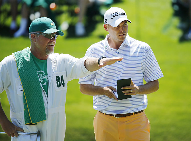 U.S. golfer Bill Haas (right) and his caddie Scott Gneiser discuss a putt on the 16th hole during the first round of the Masters golf tournament at the Augusta National Golf Club on Thursday