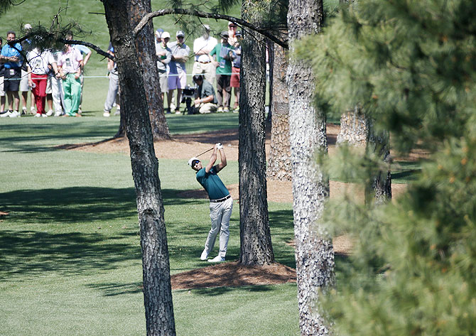 Australia's Adam Scott hits a shot from the trees on the seventh hole during the first round of the Masters golf tournament at the Augusta National Golf Club on Thursday