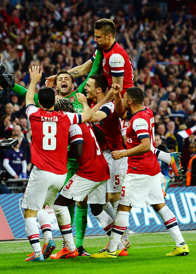 Lukasz Fabianski of Arsenal celebrates winning the penalty shoot out with teammates during the FA Cup Semi-Final against Wigan Athletic at Wembley Stadium in London on Saturday