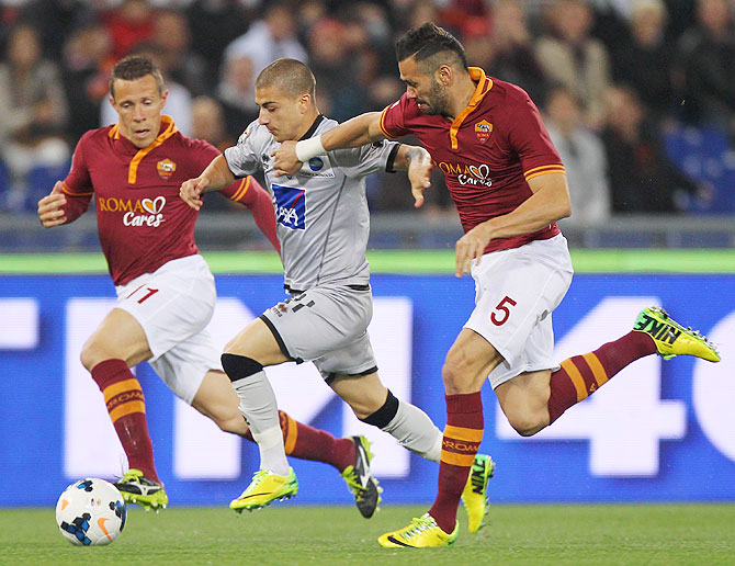 Rodrigo Taddei (left) and Leandro Castan (right) of AS Roma vie for possession agianst Giuseppe De Luca of Atalanta during their Serie A match at Stadio Olimpico in Rome on Saturday