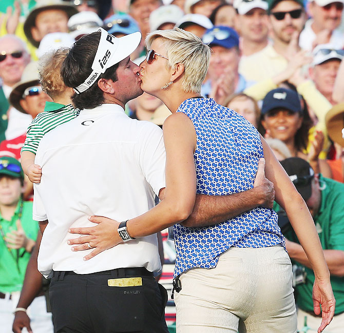 Bubba Watson of the United States celebrates with his wife Angie and their son Caleb on the 18th green after winning the 2014 Masters Tournament on Sunday