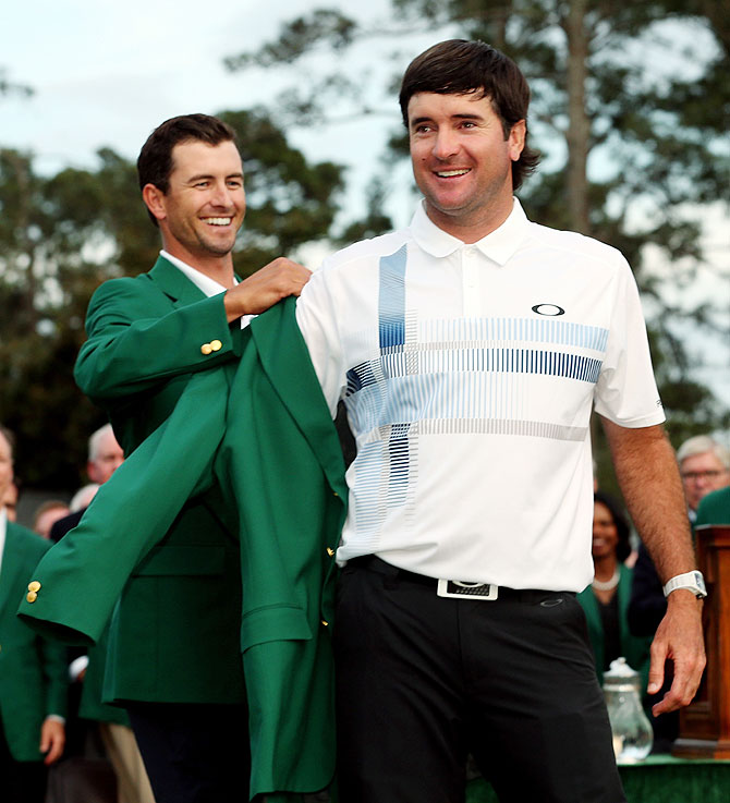 Adam Scott of Australia (left) presents Bubba Watson of the United States with the green jacket after Watson won the 2014 Masters Tournament on Sunday