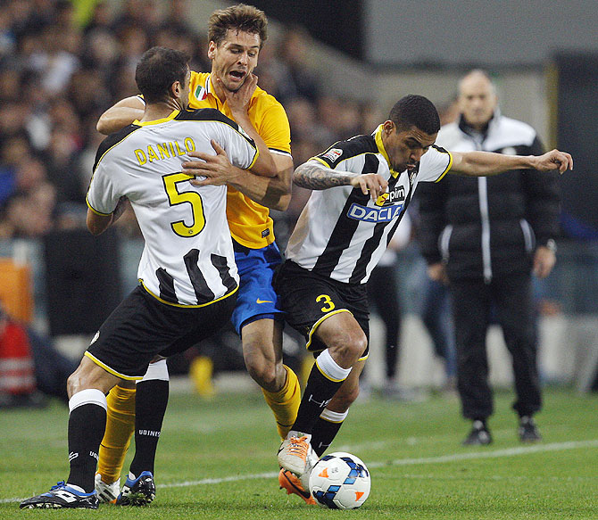 Juventus' Fernando Llorente (centre) fights for possession against Udinese's Danilo Larangeira (left) and Allan Loreiro during their Serie A match at the Friuli stadium in Udine on Monday
