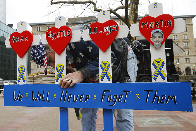 Kevin Brown puts up a hand made memorial for victims of the 2013 Boston Marathon bombings near the race's finish line in Boston, Massachusetts on Tuesday, marking the one year anniversary of the bombings