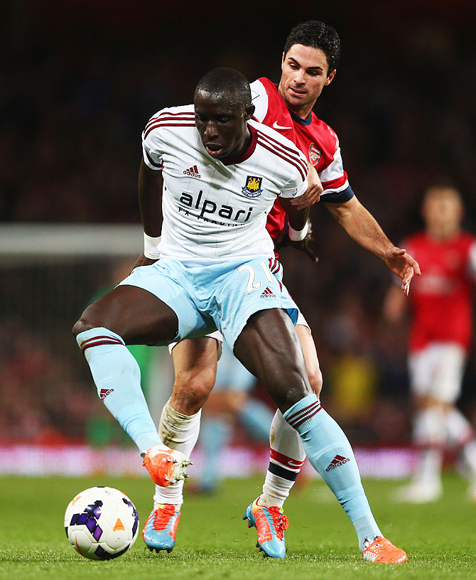 Mohamed Diame of West Ham United holds off a challenge by Mikel Arteta of Arsenal (right)