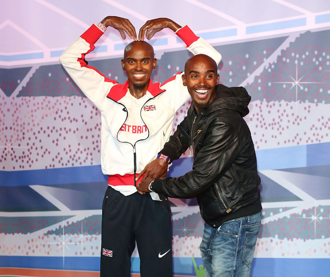 Mo Farah poses for a photocall to unveil his two waxworks