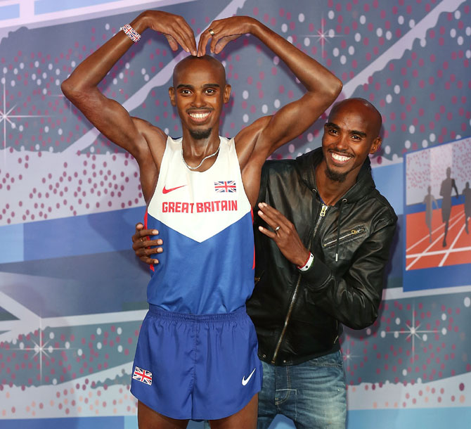 Mo Farah poses for a photocall to unveil his two waxworks