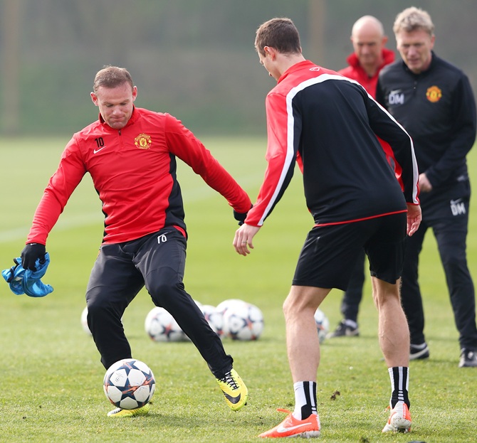 Wayne Rooney of Manchester United controls the ball past Jonny Evans during a training session