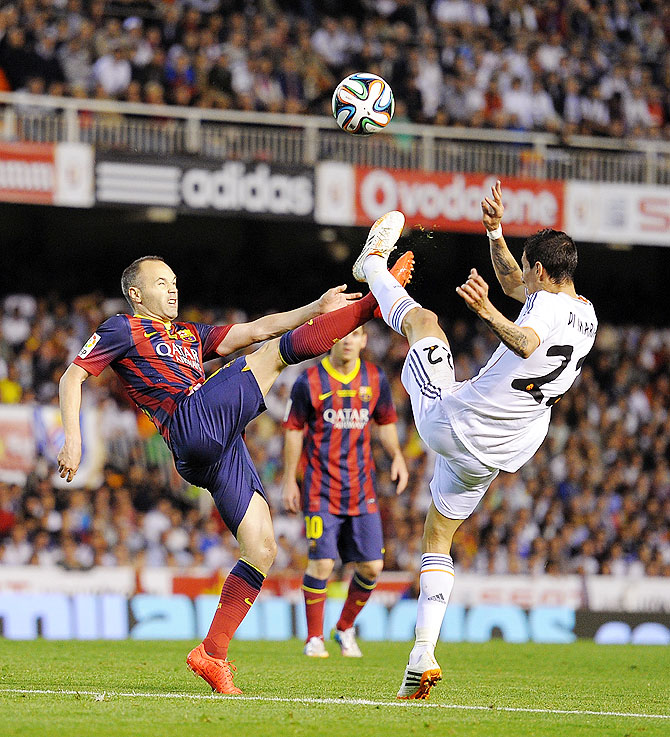 Andres Iniesta (left) of FC Barcelona battles for the ball with Angel Di Maria of Real Madrid on Wednesday