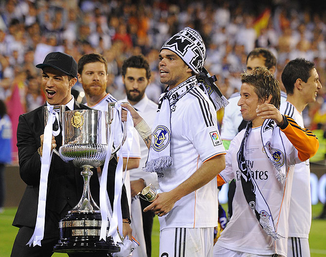 Cristiano Ronaldo, Pepe and Fabio Coentrao hold the Copa del Rey trophy after beating Barcelona at Estadio Mestalla in Valencia on Wednesday
