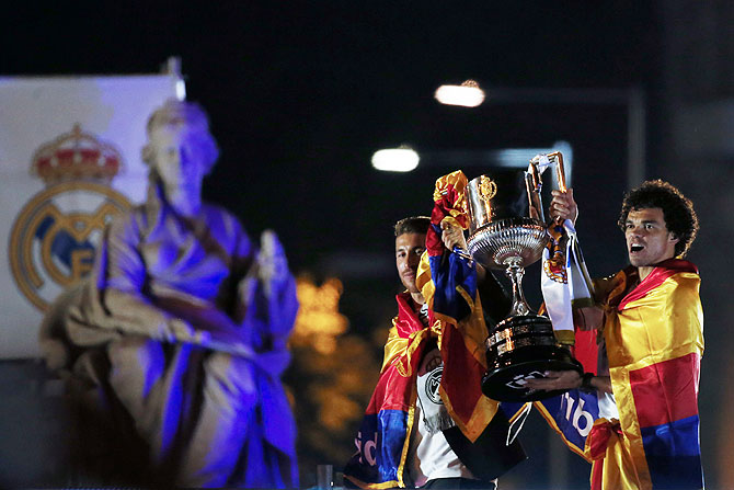 Real Madrid's players Sergio Ramos (left) and Pepe hold the King's Cup trophy at Cibeles fountain during celebrations in central Madrid on Thursday