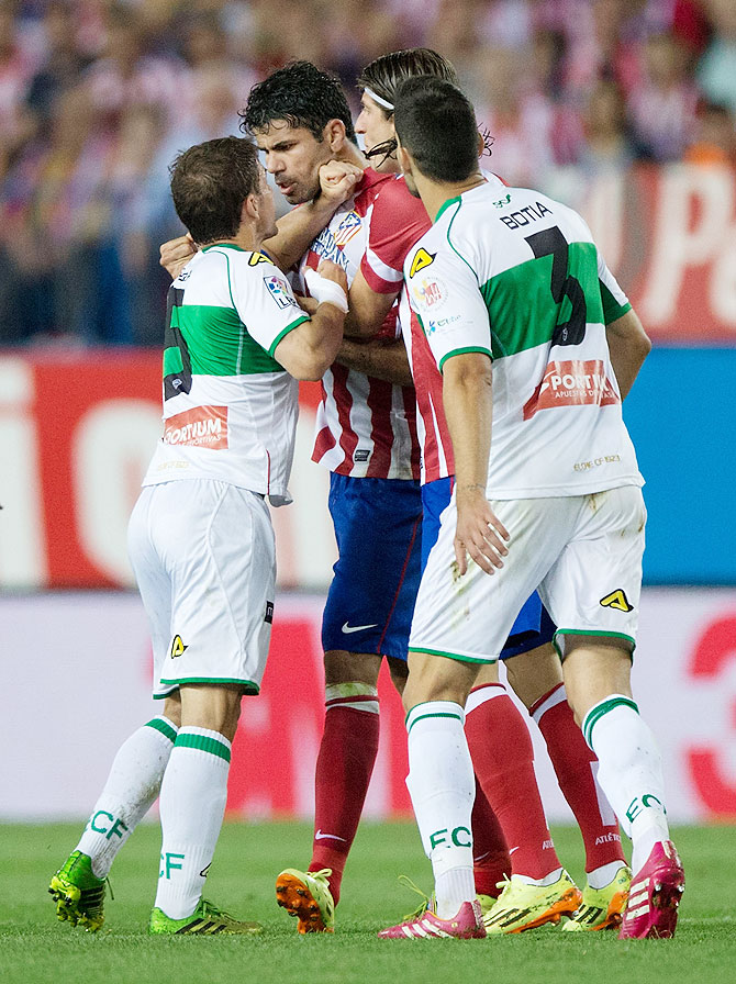 Diego Costa (2nd from left) of Atletico de Madrid argues with Alberto Rivera (left) and Alberto Tomas Botia (right) of Elche FC during their La Liga match at Vicente Calderon Stadium in Madrid on Friday